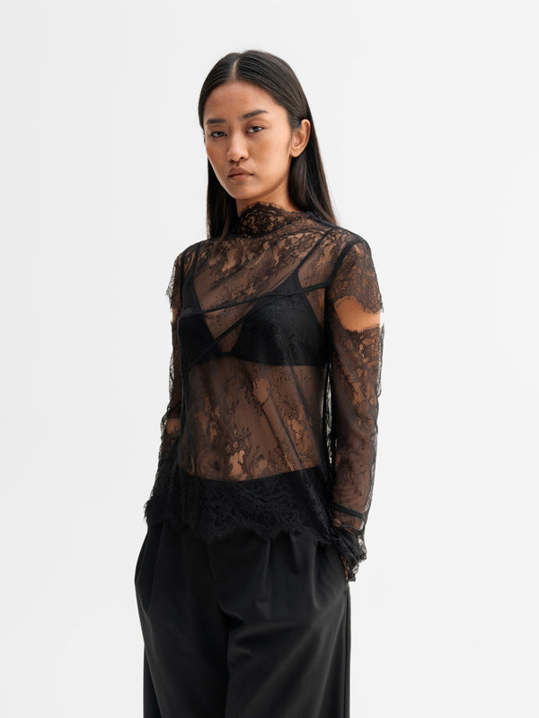 Model wearing Ahlvar Gallery Edina lace blouse in Black