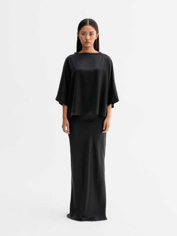 Model wearing Ahlvar Gallery Hana long logo satin skirt in Black