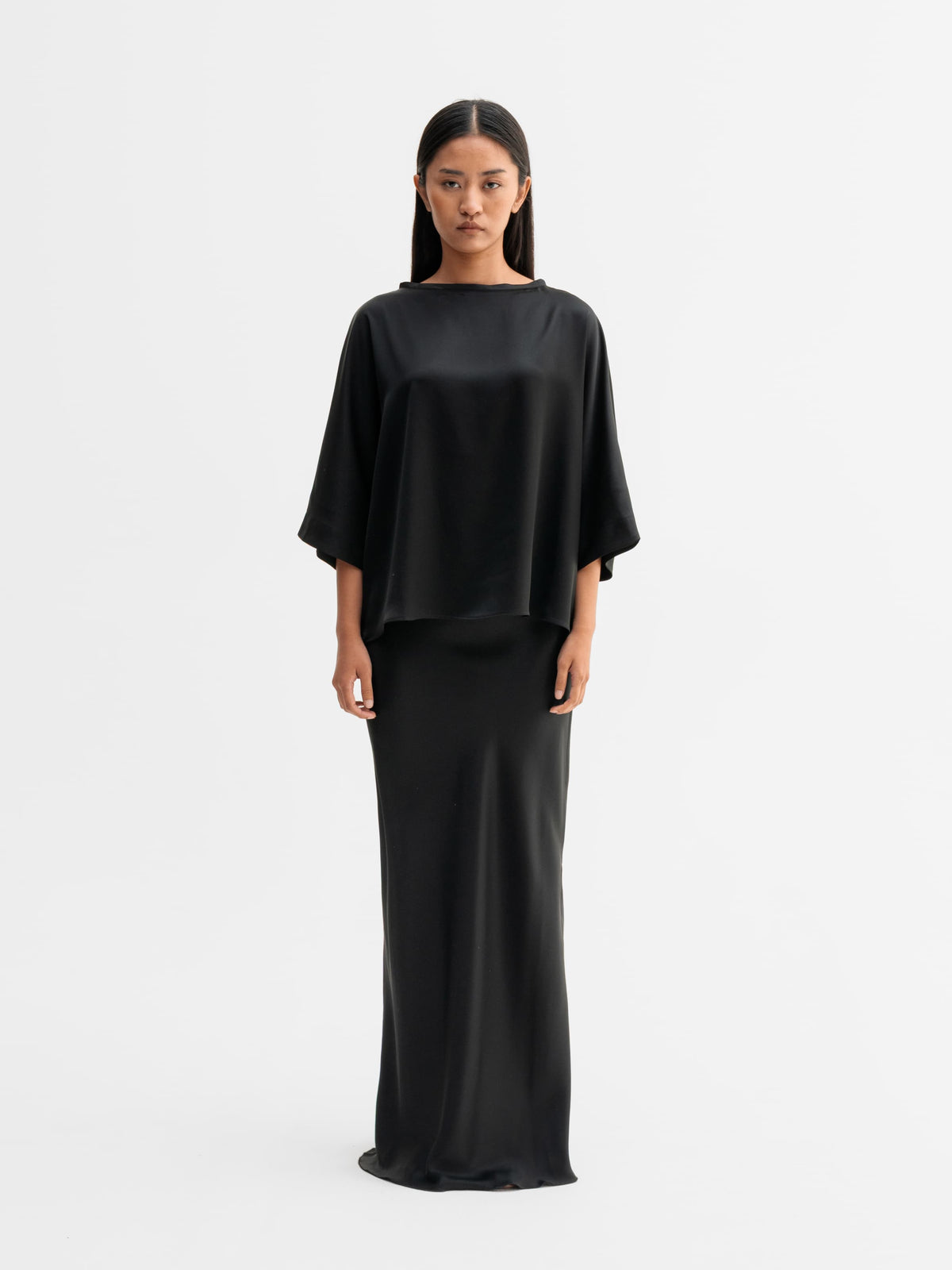 Model wearing Ahlvar Gallery Hana long logo satin skirt in Black