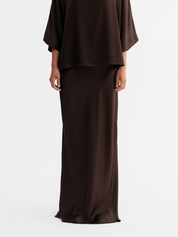 Model wearing Ahlvar Gallery Hana long logo satin skirt in Dark brown