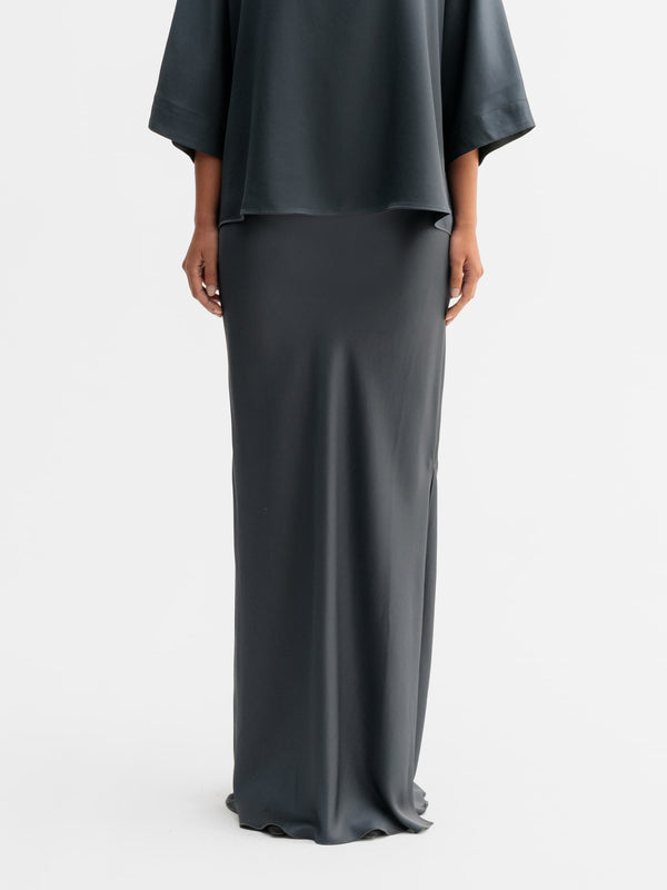 Model wearing Ahlvar Gallery Hana long logo satin skirt in Dark grey
