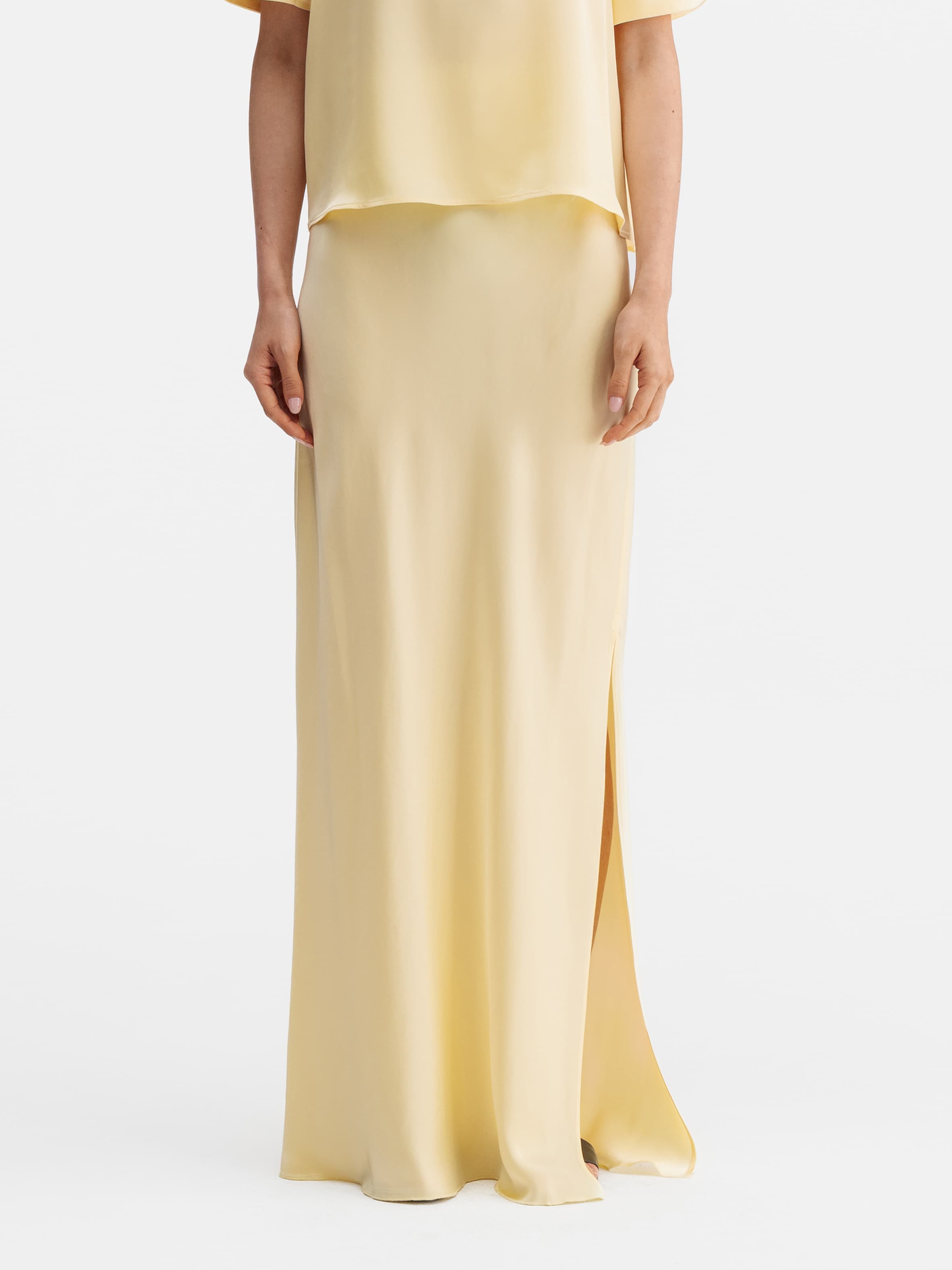 Model wearing Ahlvar Gallery Hana long logo satin skirt light yellow