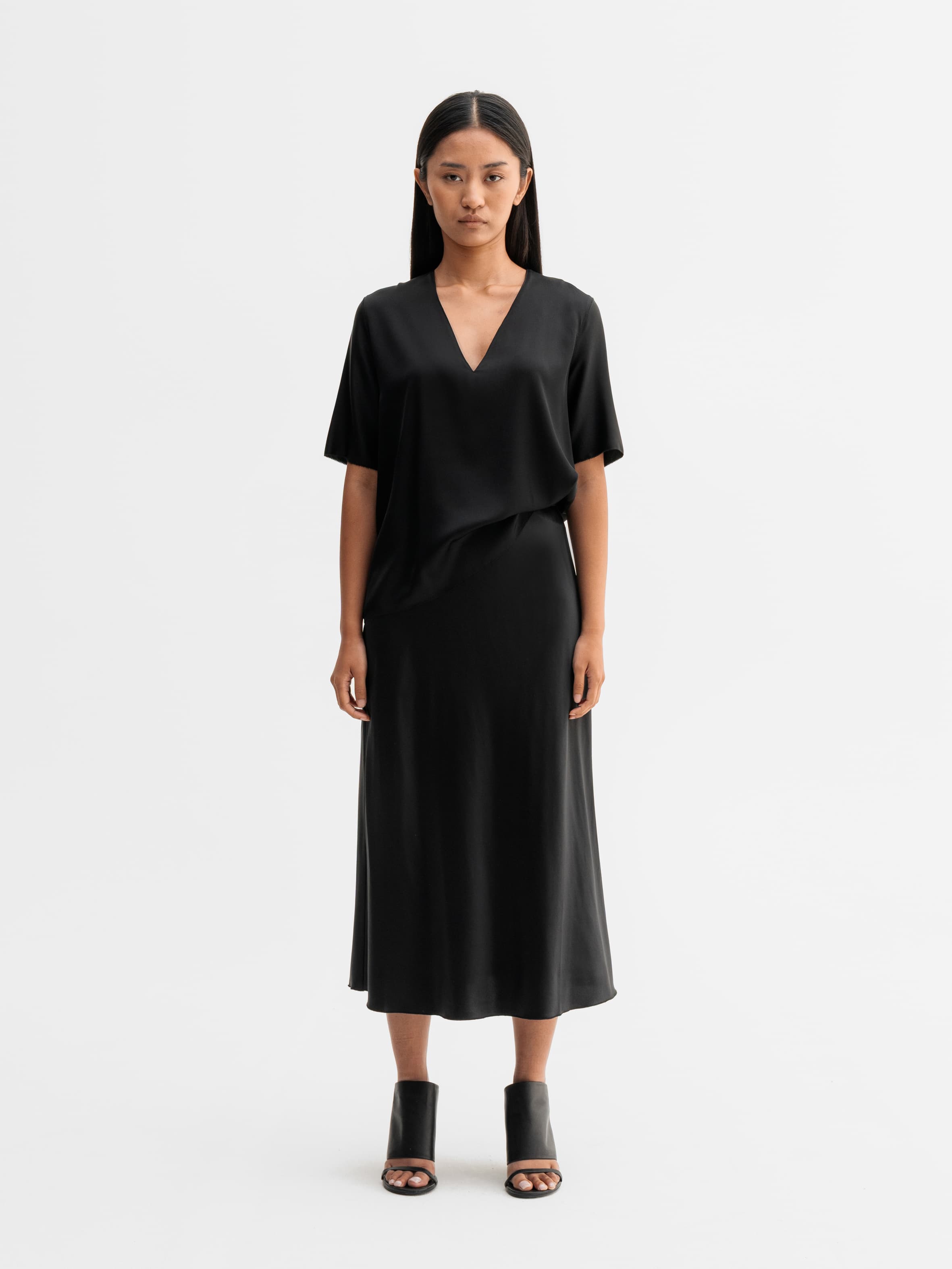 Model wearing Ahlvar Gallery Hana satin silk skirt in Black