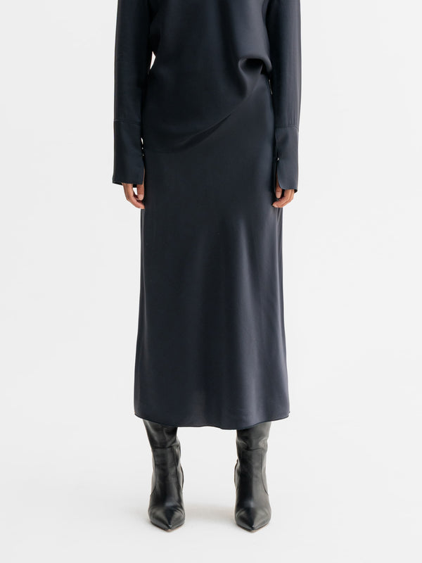 Model wearing Ahlvar Gallery Hana satin silk skirt in Blue grey