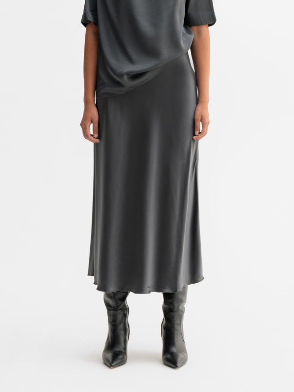 Model wearing Ahlvar Gallery Hana satin silk skirt in Dark grey