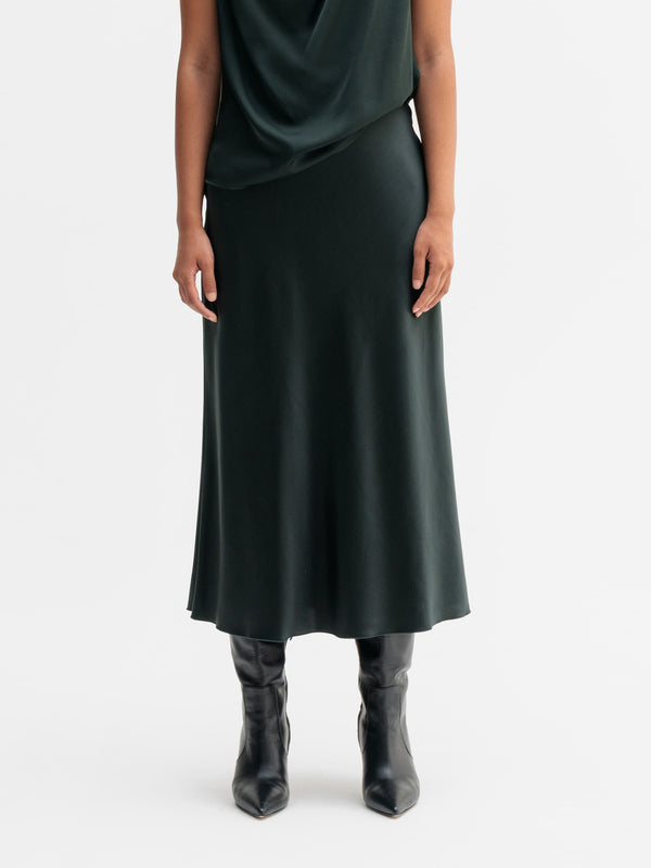 Model wearing Ahlvar Gallery Hana satin silk skirt in Deep forest