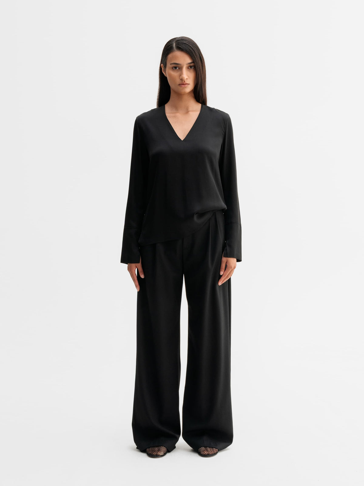 Model wearing Ahlvar Gallery Kelly v-neck silk blouse in Black