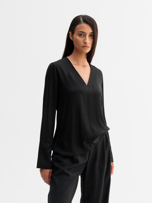 Model wearing Ahlvar Gallery Kelly v-neck silk blouse in Black