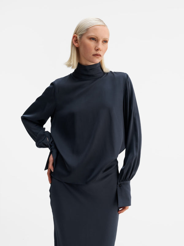 Model wearing Ahlvar Gallery Luna silk blouse blue grey