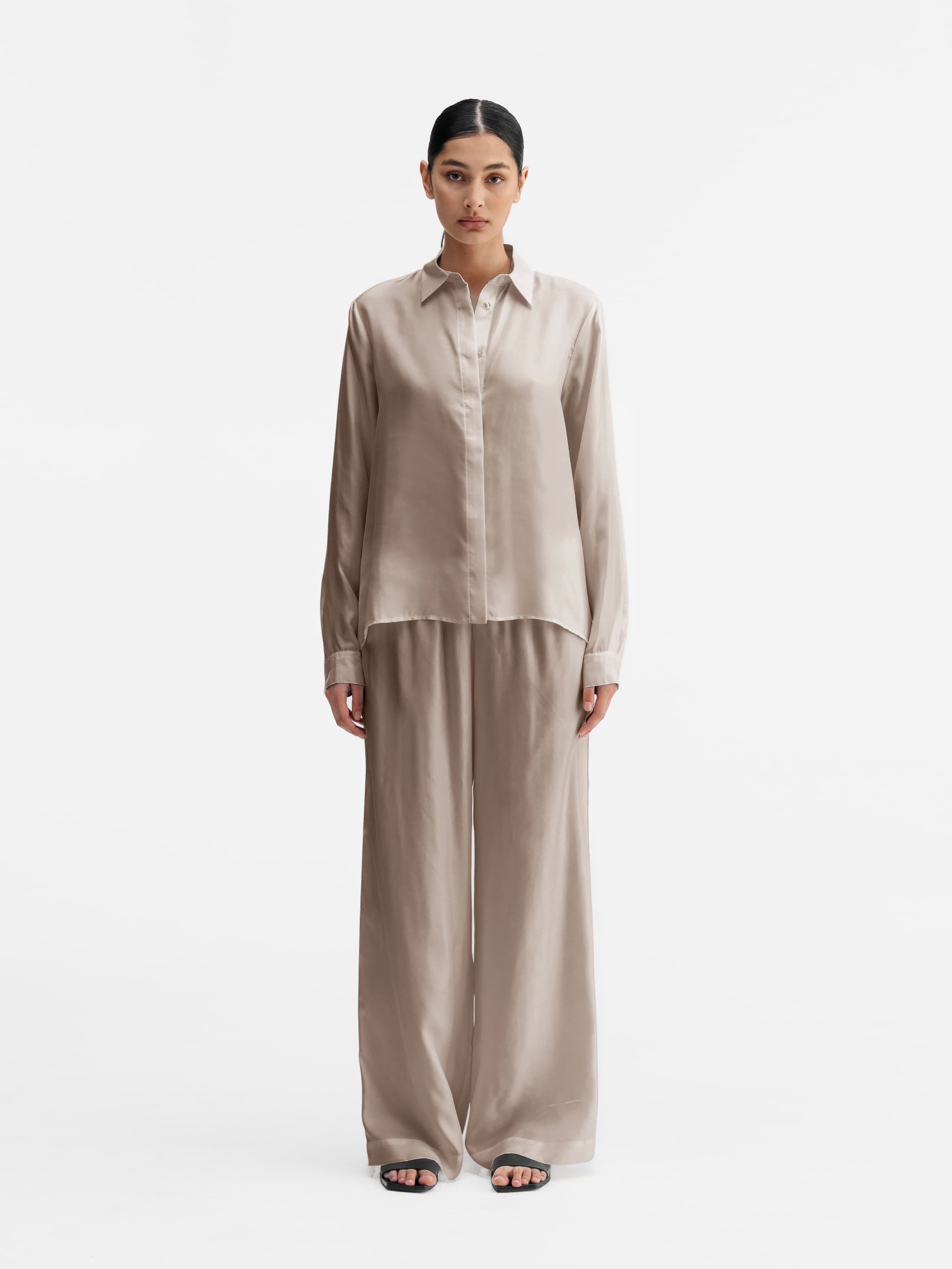 Model wearing Ahlvar Gallery Madoka silk twill trousers greige