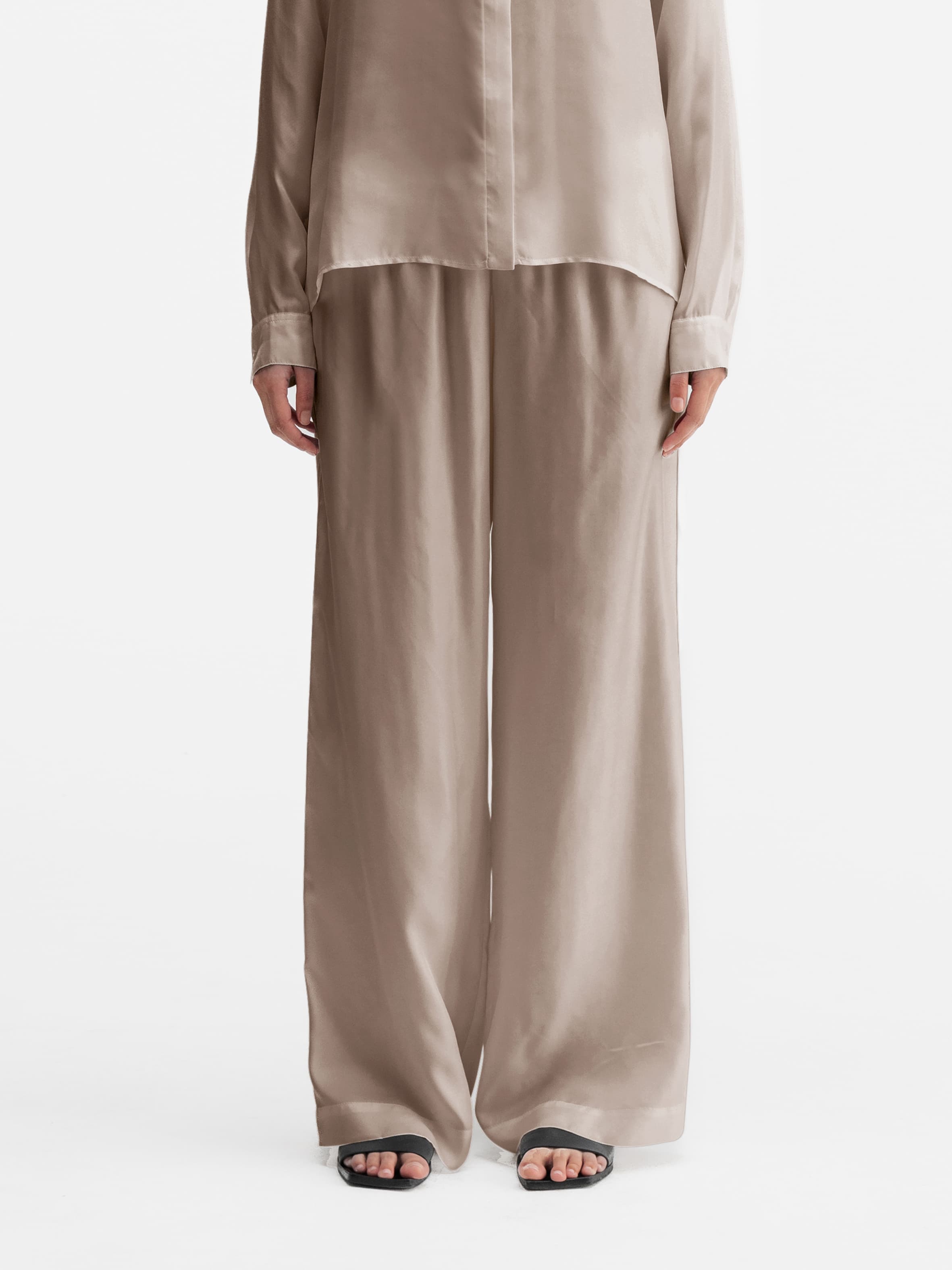 Model wearing Ahlvar Gallery Madoka silk twill trousers greige