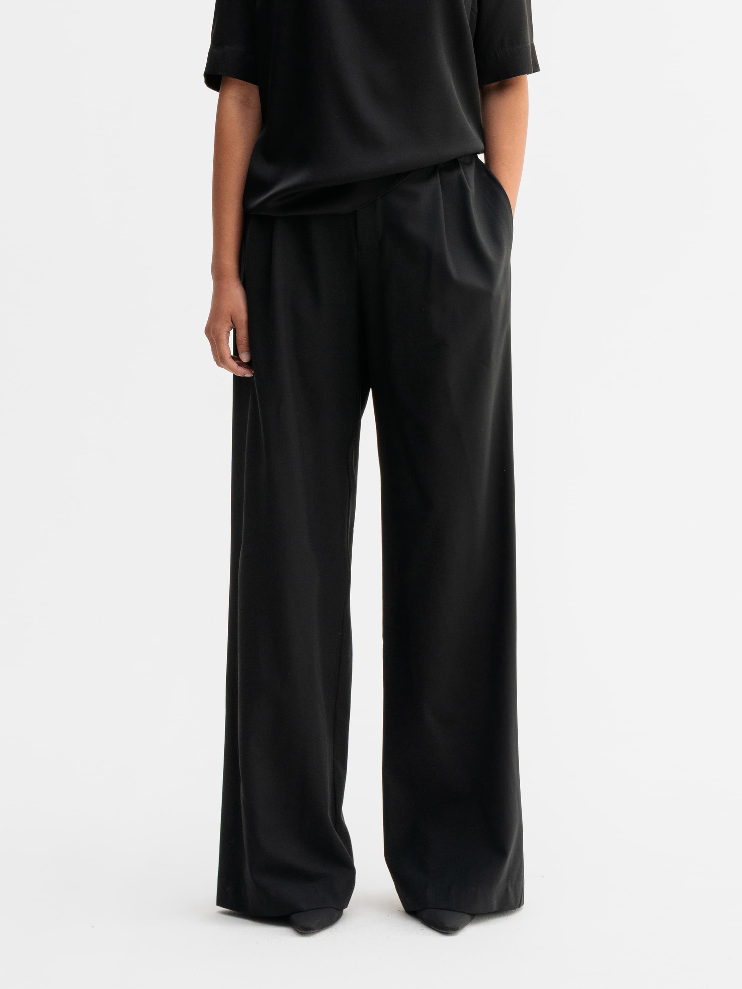 Model wearing Ahlvar Gallery Mel wool trousers in Black