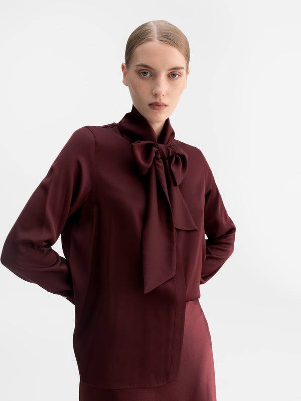 Model wearing Ahlvar Gallery Miki silk blouse in Burgundy