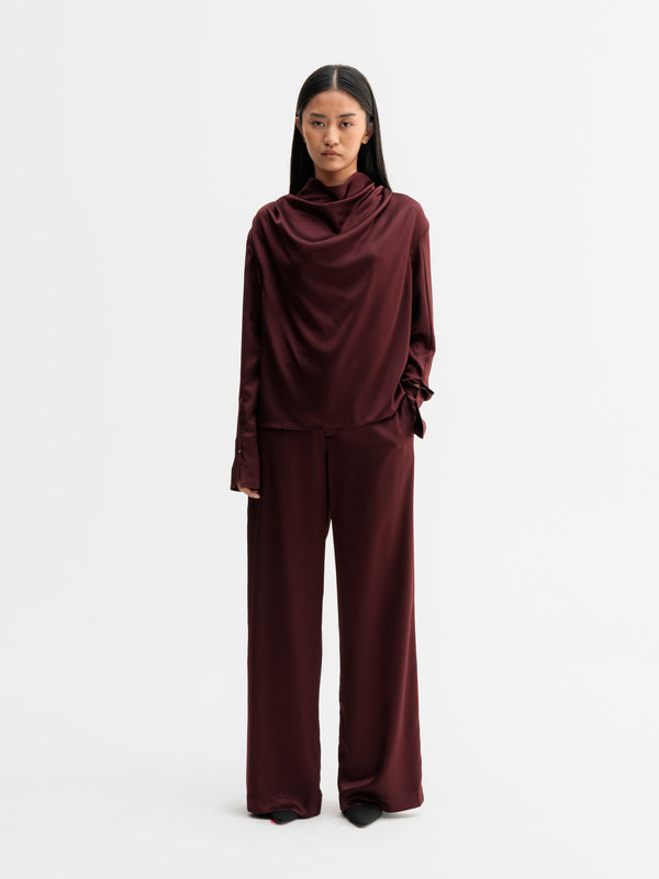 Model wearing Ahlvar Gallery Miko satin blouse in Burgundy