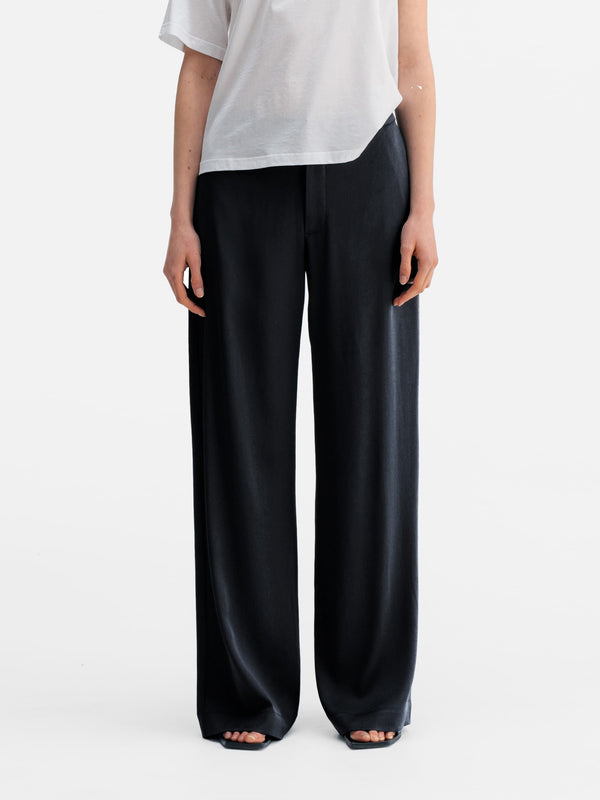 Model wearing Ahlvar Gallery Mila heavy satin trousers blue grey
