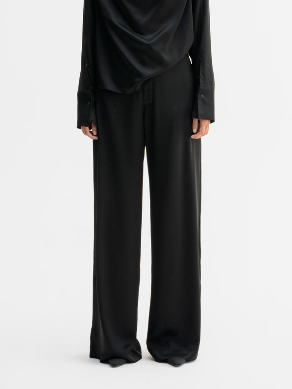 Model wearing Ahlvar Gallery Mila satin trousers in Black
