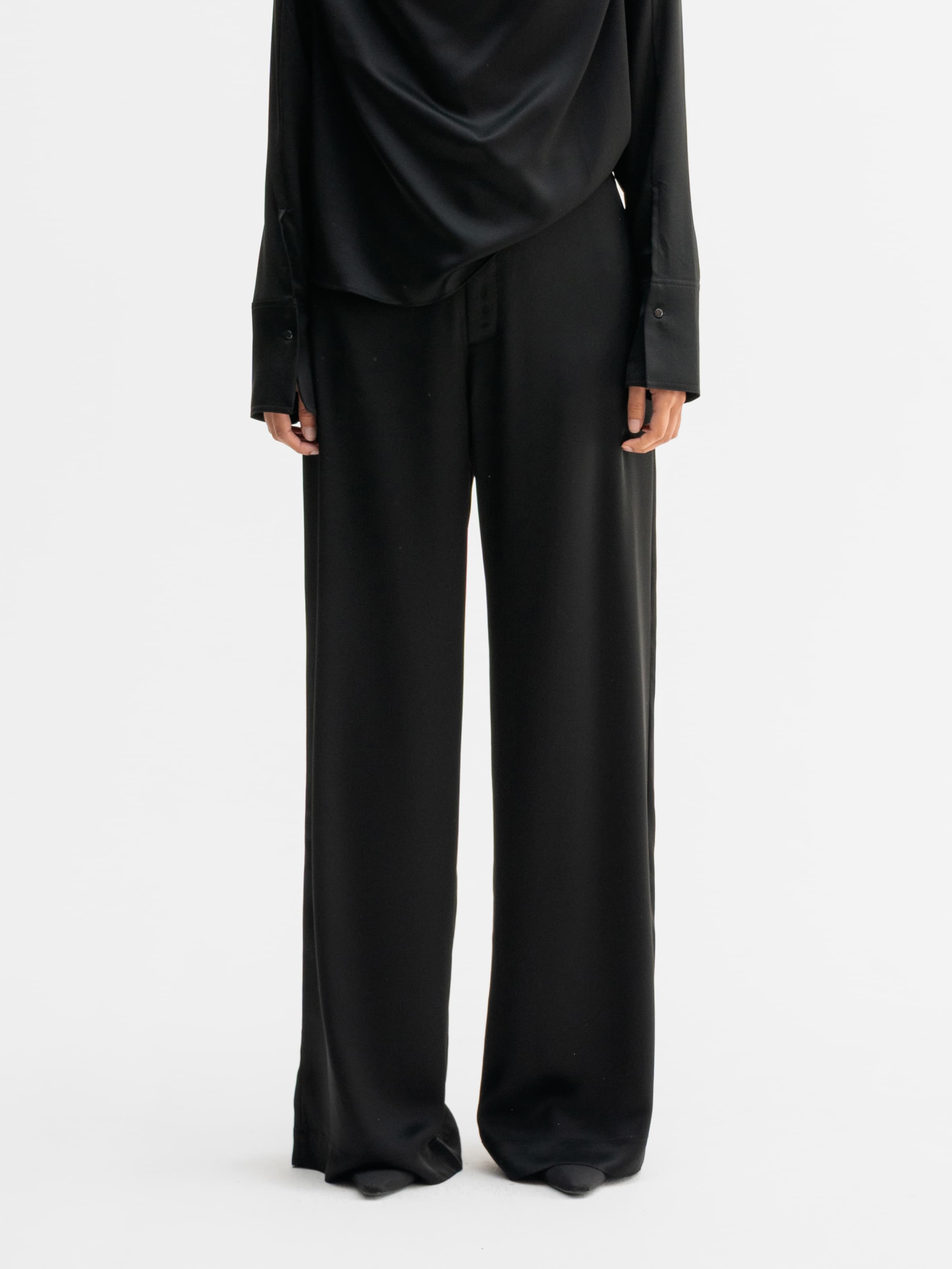 Model wearing Ahlvar Gallery Mila satin trousers in Black