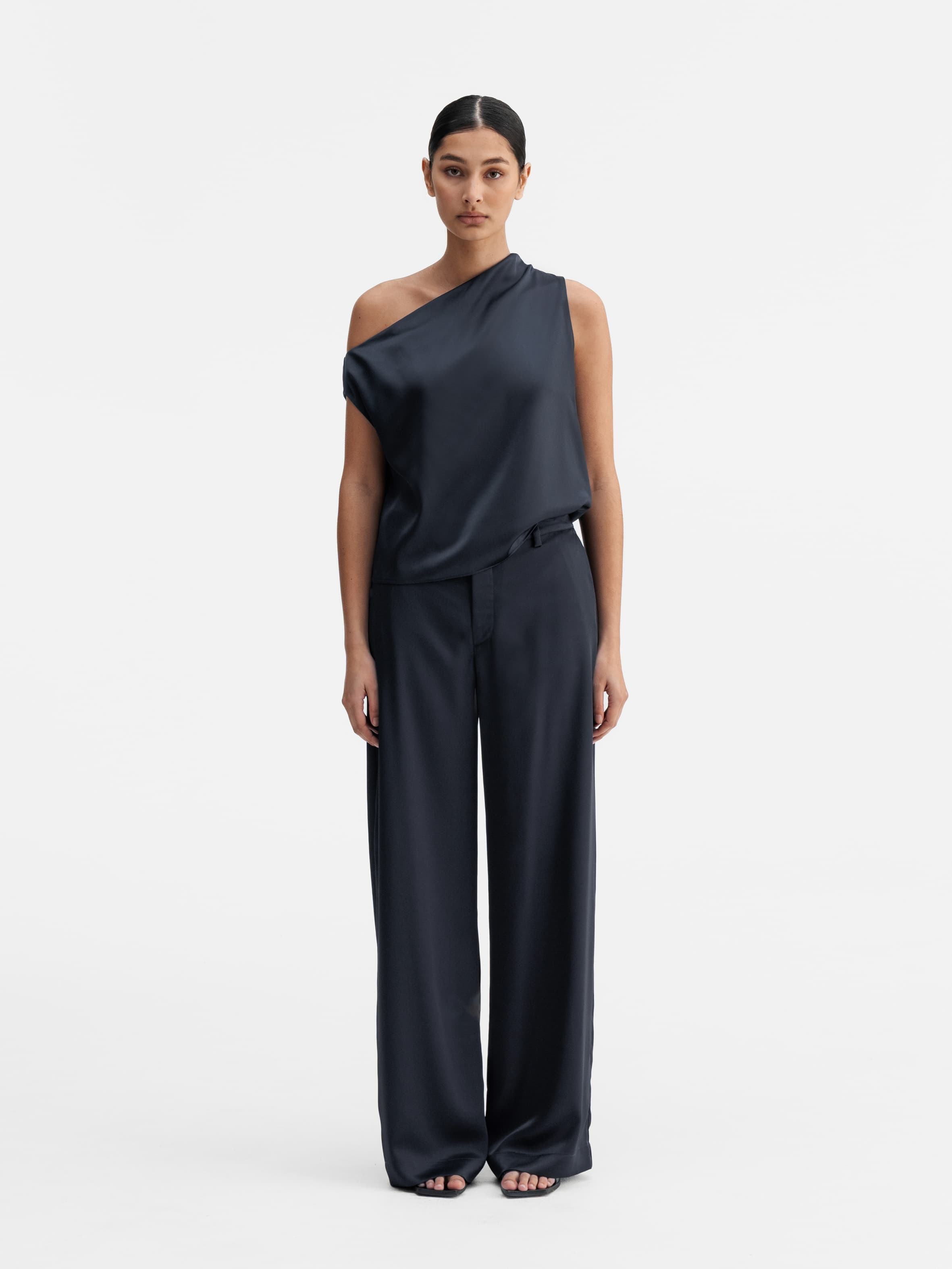 Model wearing Ahlvar Gallery Mila satin trousers blue grey