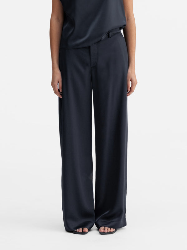 Model wearing Ahlvar Gallery Mila satin trousers blue grey
