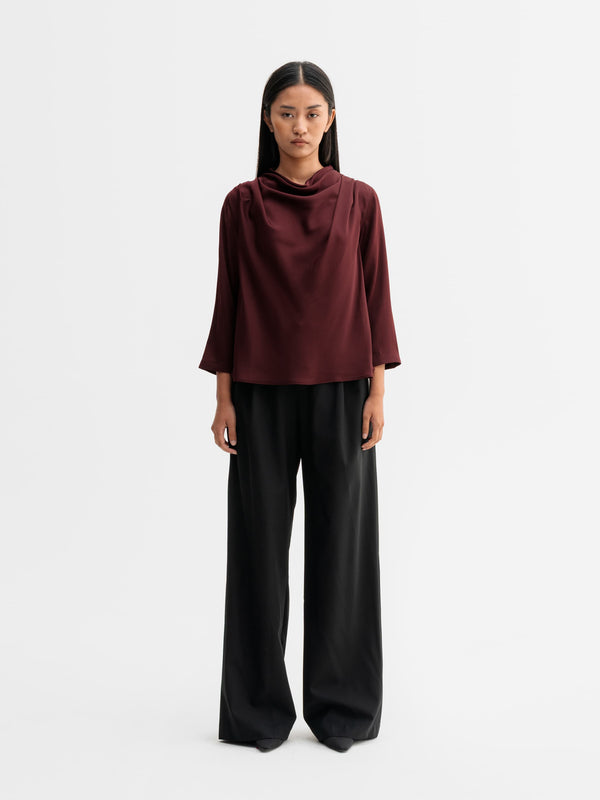 Model wearing Ahlvar Gallery Minou silk blouse in Burgundy