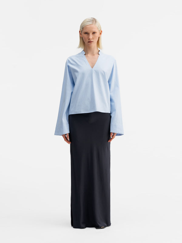 Model wearing Ahlvar Gallery Nina v-neck oxford blouse light blue