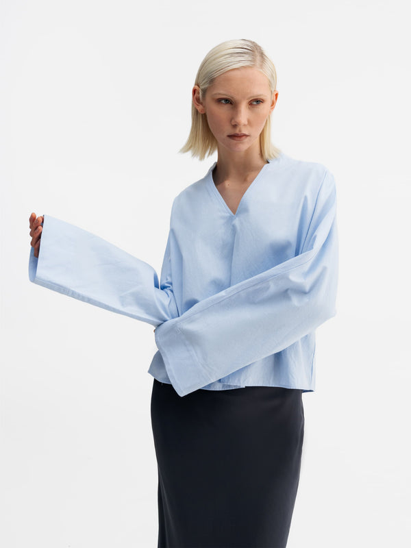 Model wearing Ahlvar Gallery Nina v-neck oxford blouse light blue