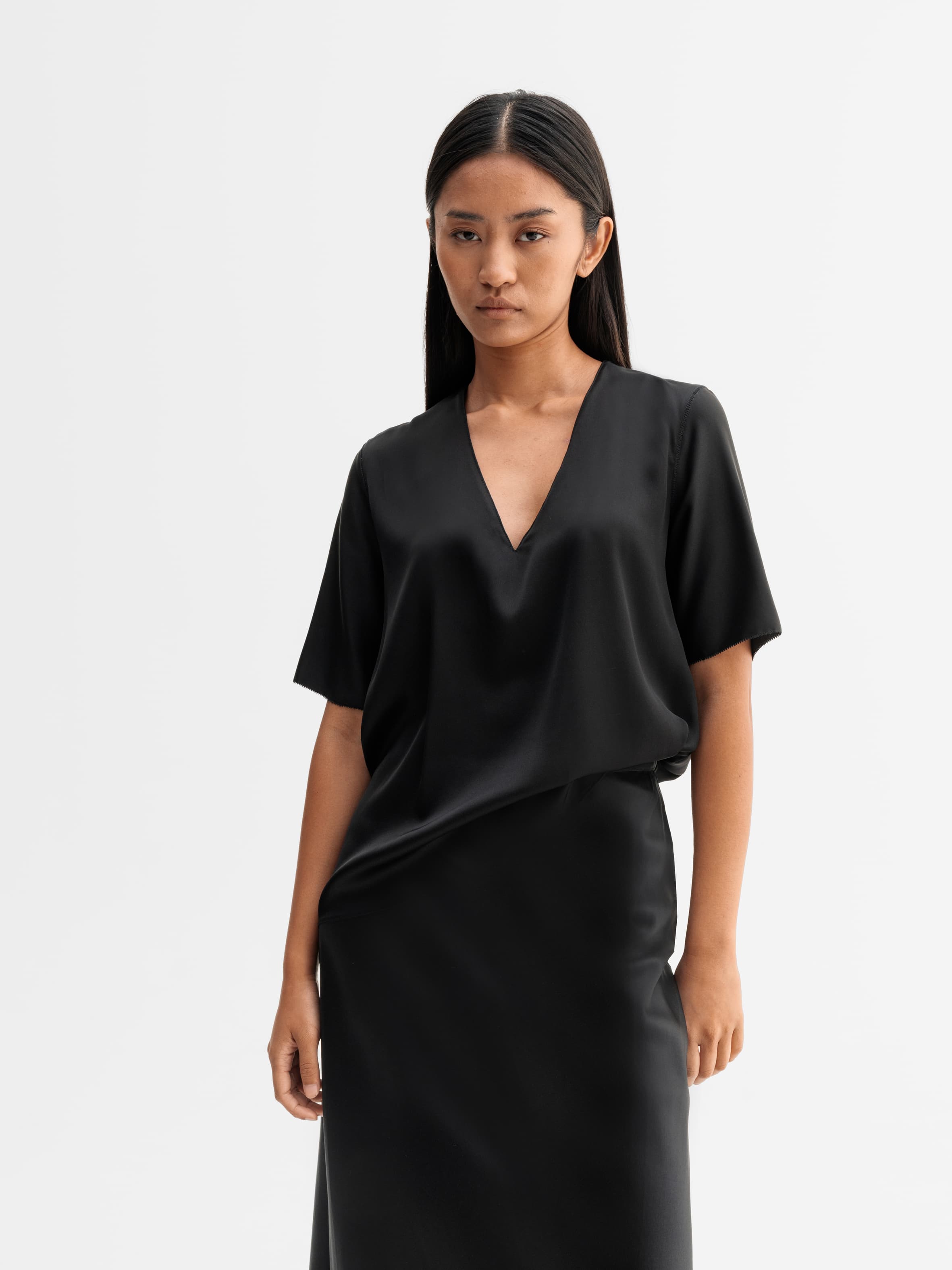 Model wearing Ahlvar Gallery Yoli v-neck silk blouse in Black
