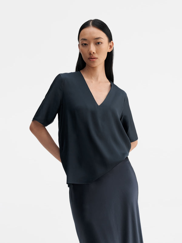 Model wearing Ahlvar Gallery Yoli v-neck silk blouse blue grey