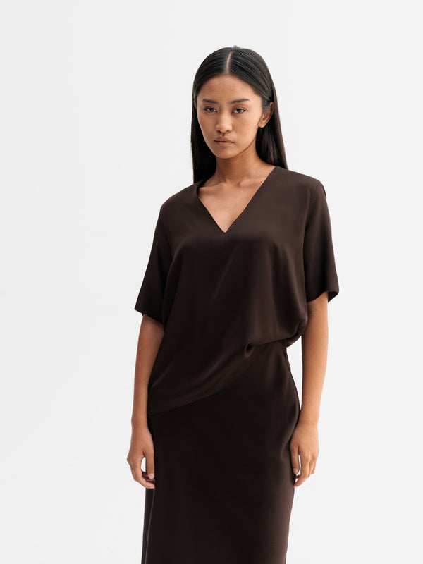 Model wearing Ahlvar Gallery Yoli v-neck silk blouse in Dark brown