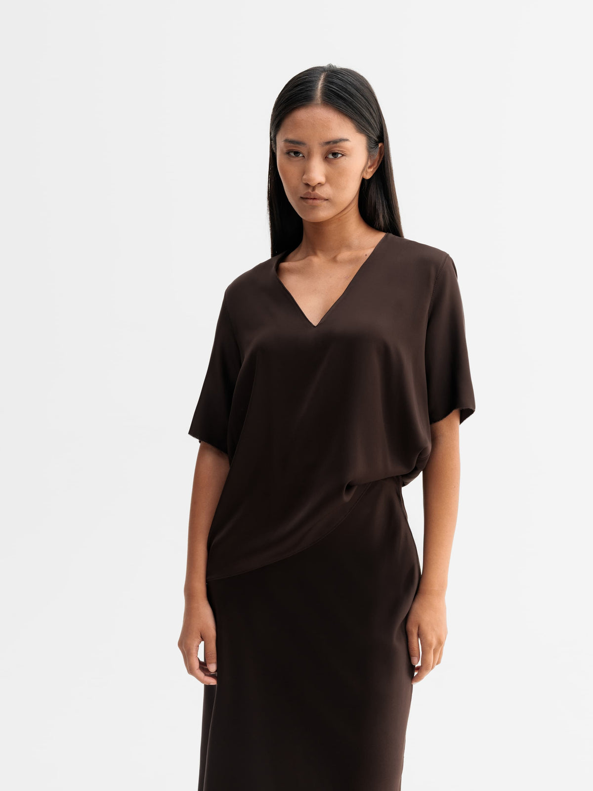 Model wearing Ahlvar Gallery Yoli v-neck silk blouse in Dark brown