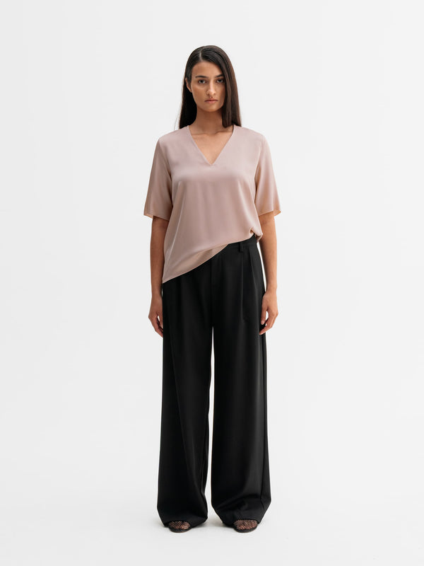 Model wearing Ahlvar Gallery Yoli v-neck silk blouse in Dusty pink