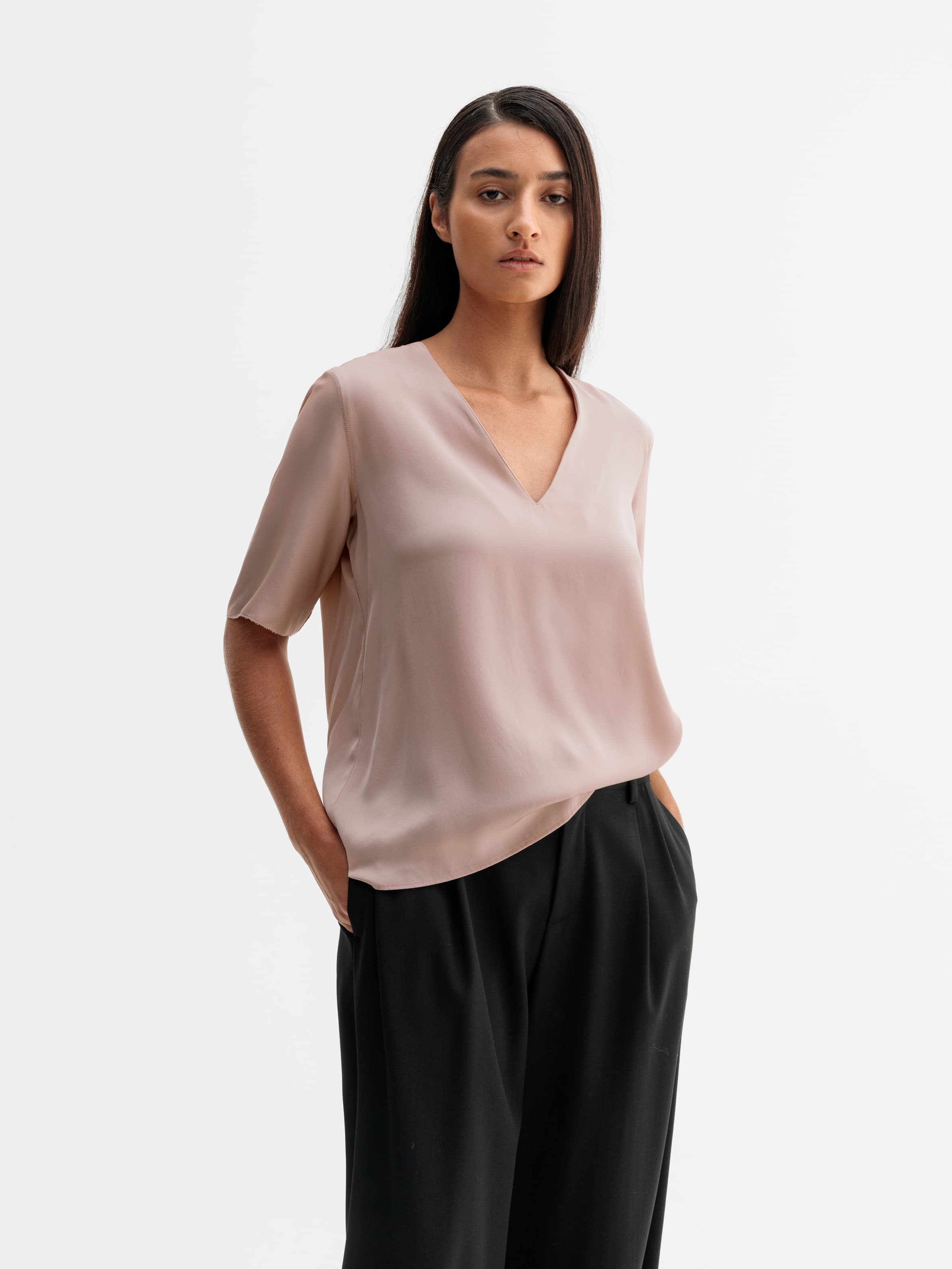 Model wearing Ahlvar Gallery Yoli v-neck silk blouse in Dusty pink