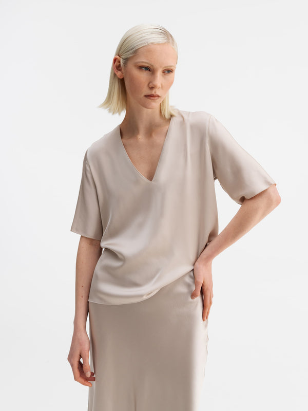 Model wearing Ahlvar Gallery Yoli v-neck silk blouse greige