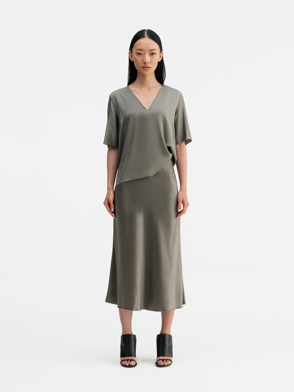 Model wearing Ahlvar Gallery Yoli v-neck silk blouse light military