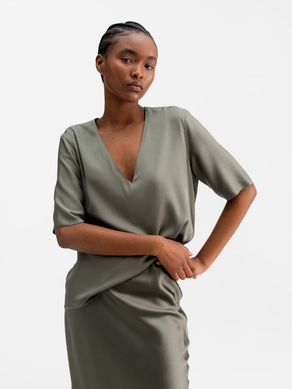 Model wearing Ahlvar Gallery Yoli v-neck silk blouse light military